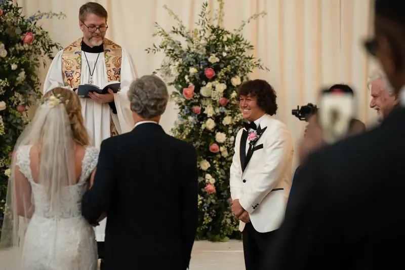 Groom watching bride approach altar during ceremony