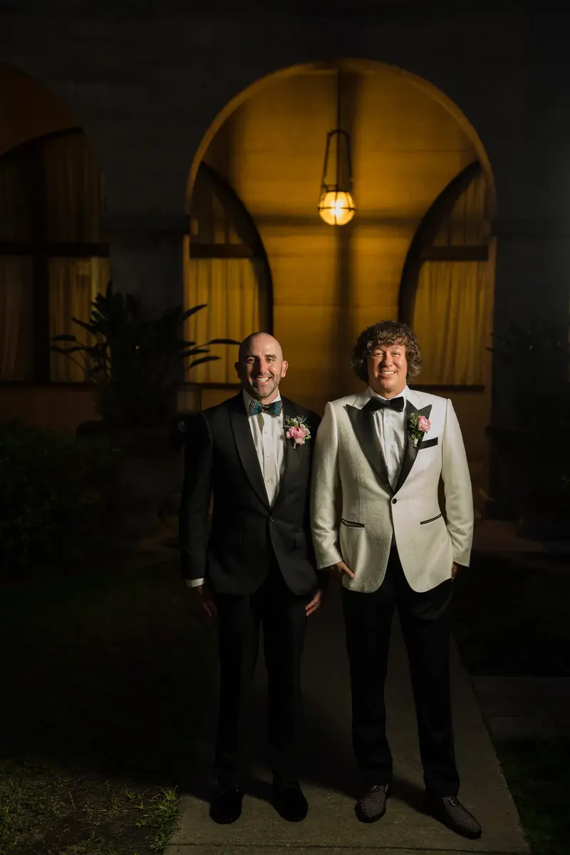 Groom with best man in evening portrait under archway