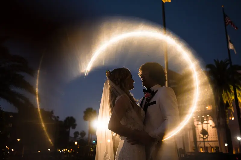 Silhouette of couple embracing with sparkler circle at night