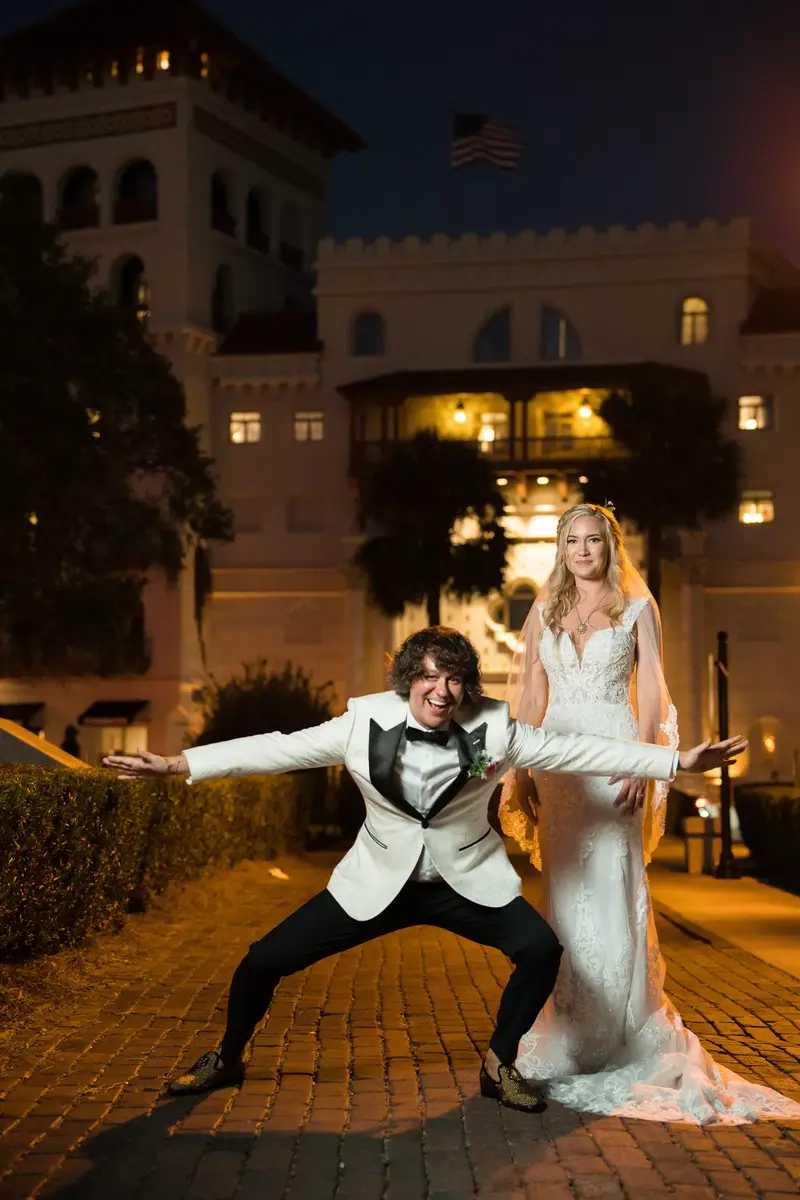 Fun couple portrait in front of Casa Monica hotel at night