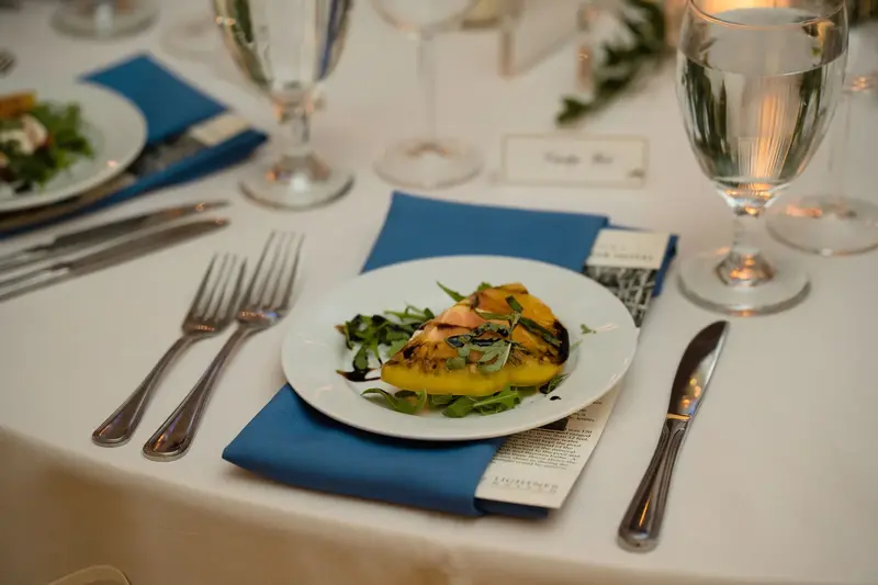 Reception table setting with blue napkins and plated dinner