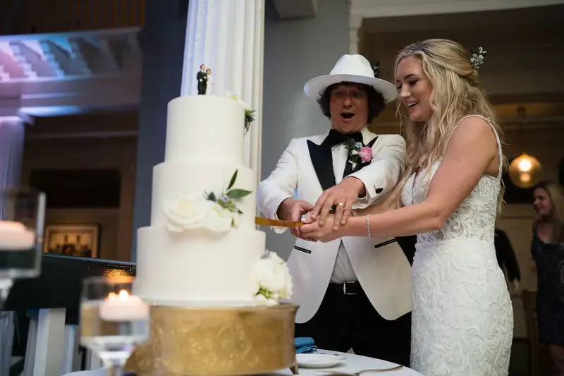 Couple cutting their three-tier wedding cake