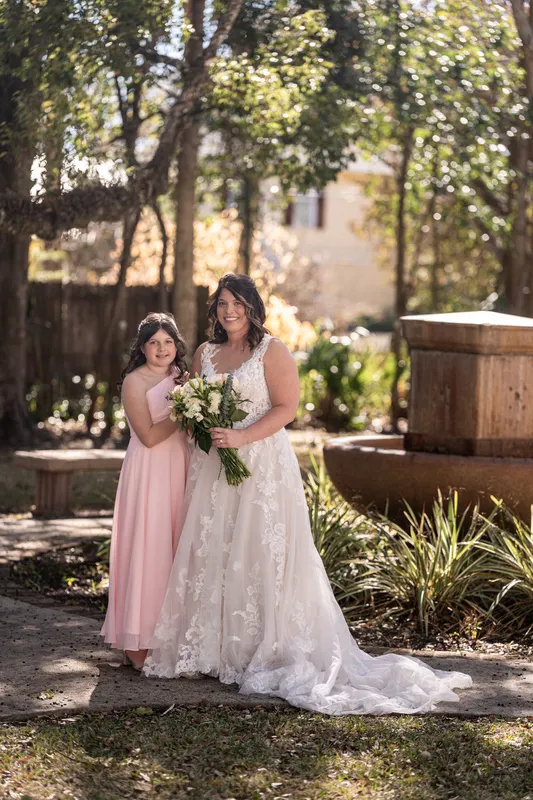 Jennifer and her daughter posing together with bouquet in a garden setting