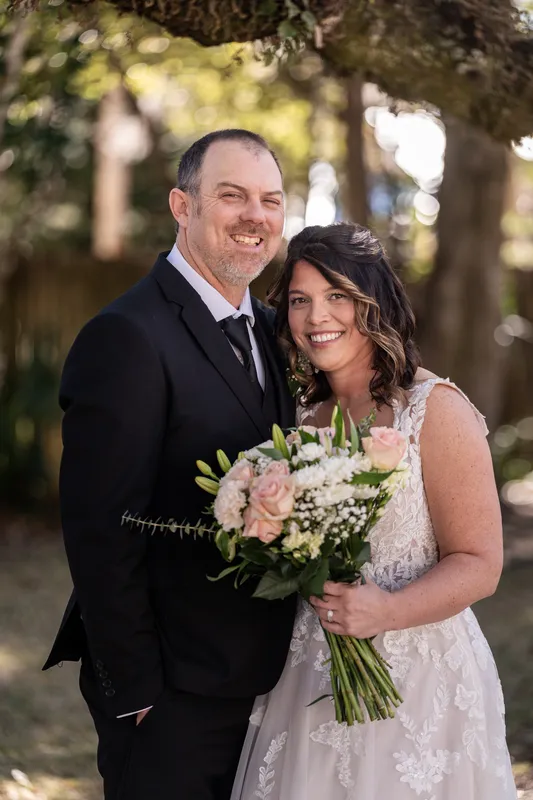 Donnie and Jennifer smiling together in a close portrait with her bouquet