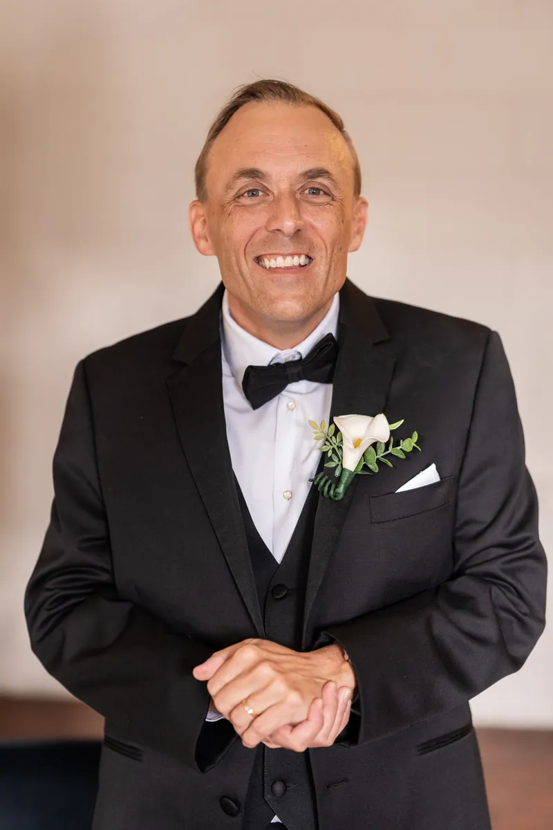 Groom portrait in black tux with calla lily boutonniere