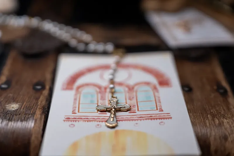 Diamond necklace draped across white invitation card with building illustration at Lightner Museum.