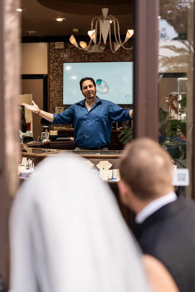 Jewelry store owner greeting the couple with open arms on St. George Street