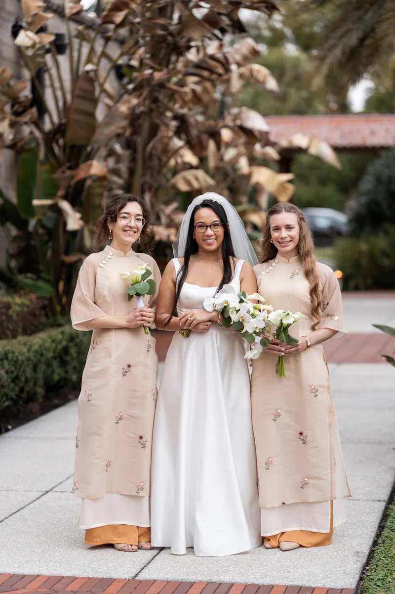 Bride with bridesmaids wearing Vietnamese ao dai holding orchid and calla lily bouquets