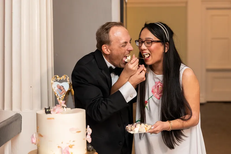 Couple feeding each other cake at the Lightner Museum reception