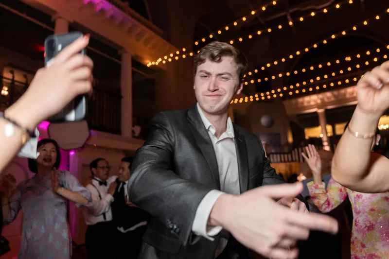 Guest dancing under string lights at the Lightner Museum reception