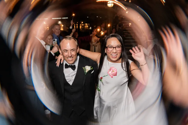 Ring-shot of couple waving and smiling during sparkler exit from the Lightner Museum