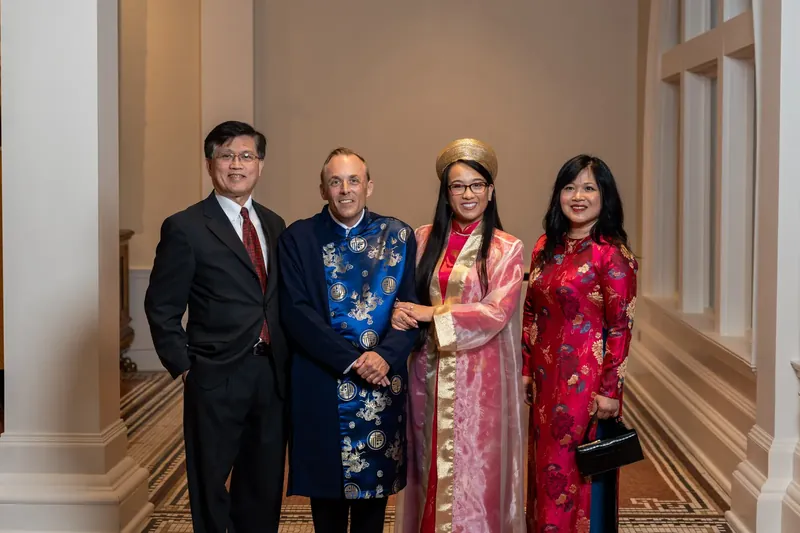 Jason in a blue floral silk jacket stands between Elizabeth and three other family members dressed in coordinating