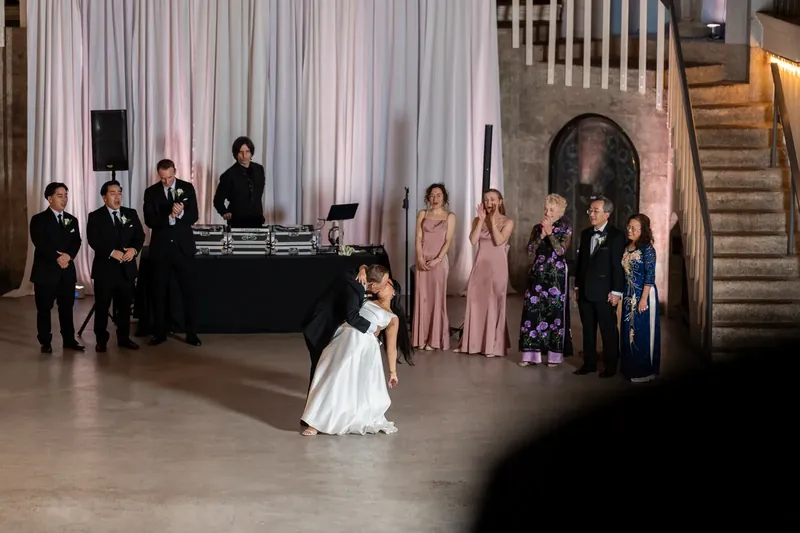 Elizabeth twirls in her white wedding dress while dancing at Lightner Museum, with Jason and wedding party members looking