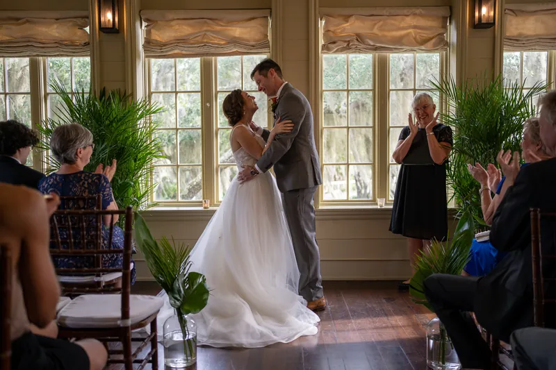 The couple embraces as guests applaud around them following their first kiss as a married couple.