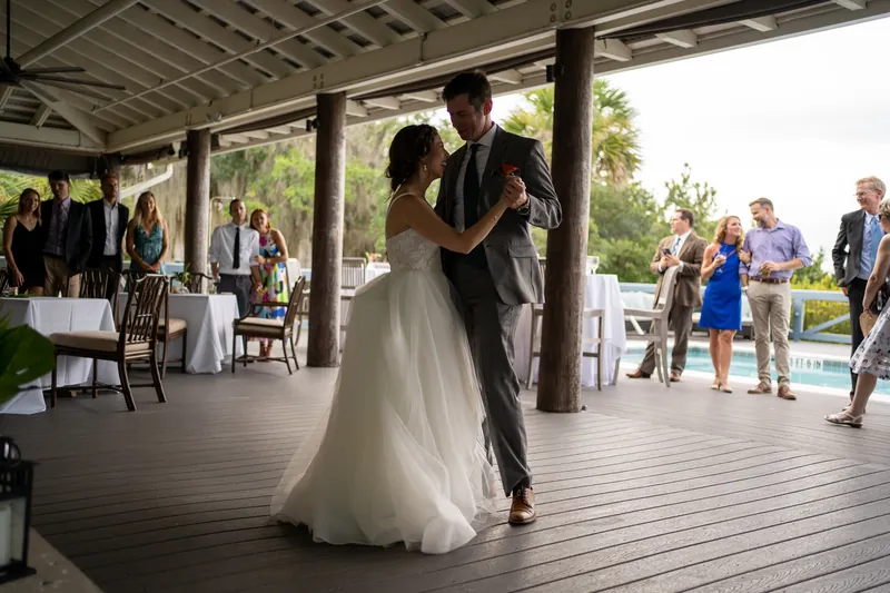 Emma twirls in her flowing white gown while dancing with Kyle on the waterfront pavilion deck.