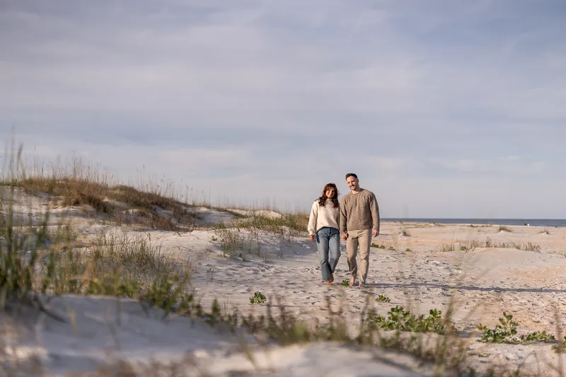 Couple walking through sandy dunes at Anastasia State Park