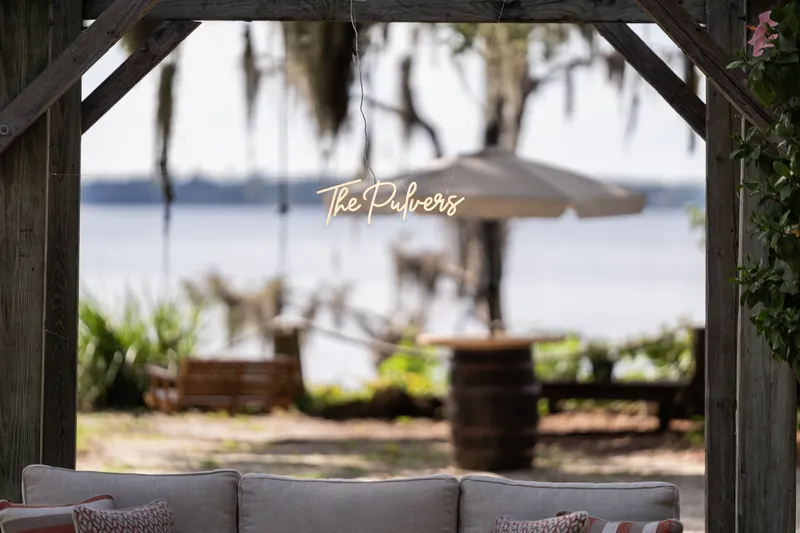La Venture" signage frames a waterfront view with umbrellas and lounge seating at the venue.
