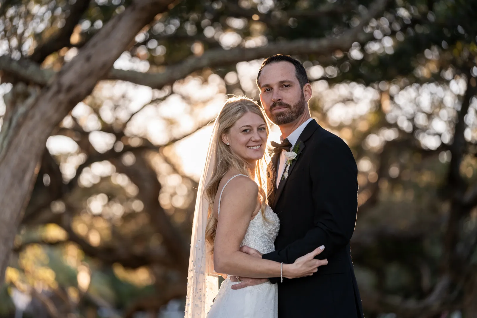 Couple walking under oak trees at golden hour St Augustine