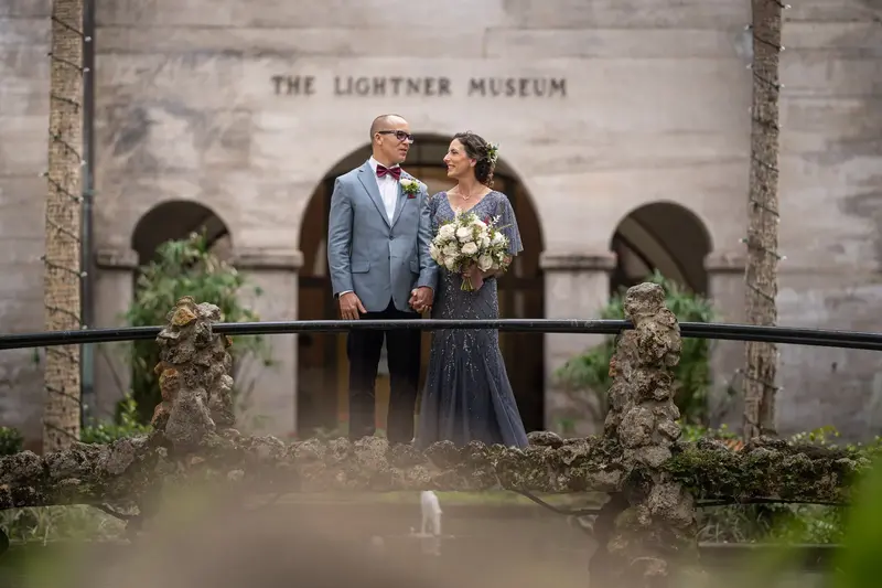 Couple on the bridge with Lightner Museum sign behind them
