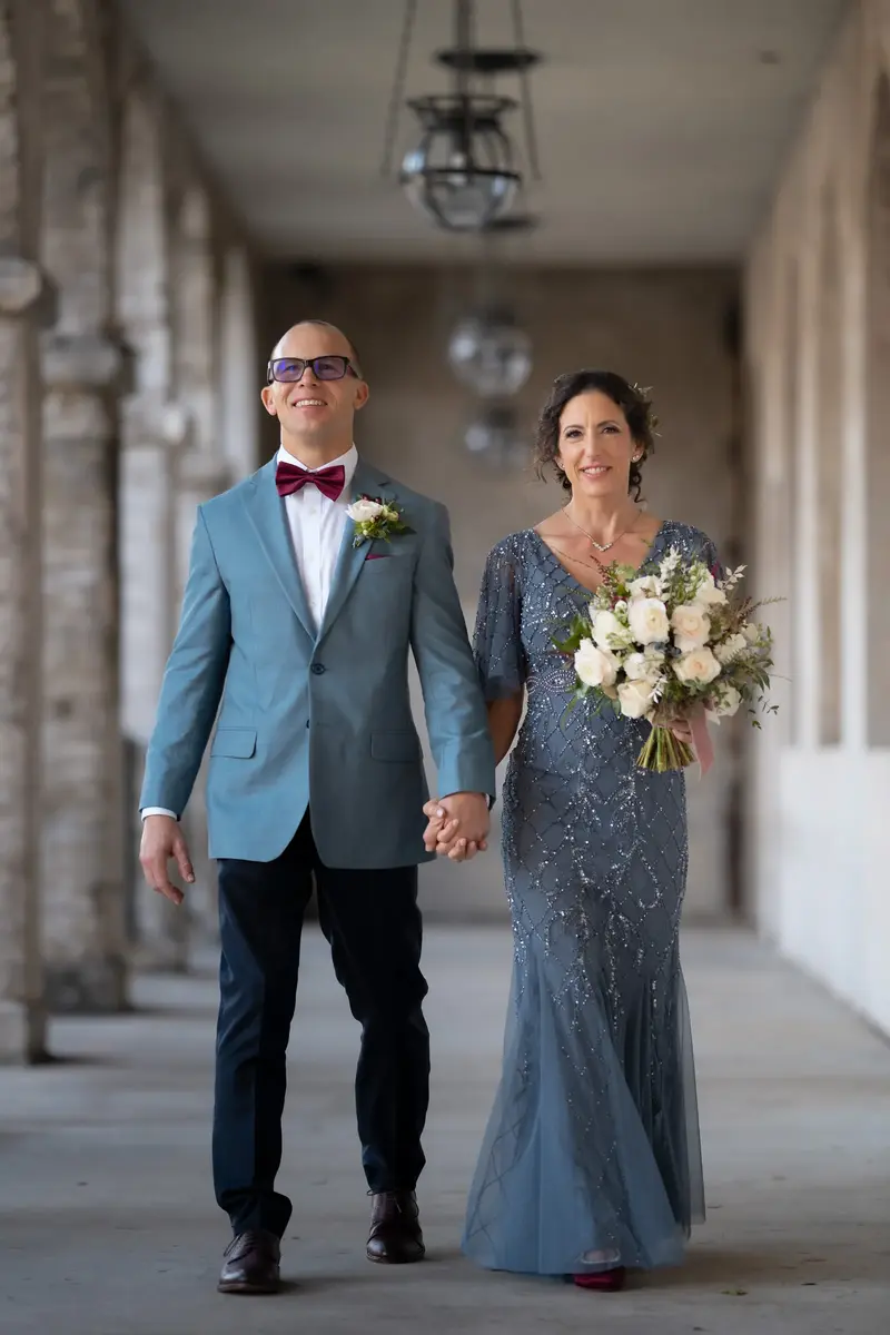 Couple walking hand in hand through the colonnade
