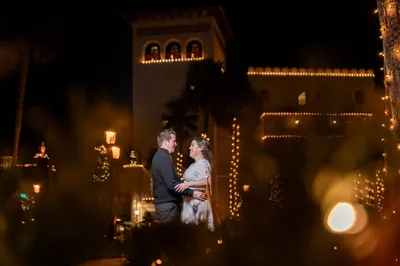 Romantic couple portrait with Flagler College tower lit up during Nights of Lights