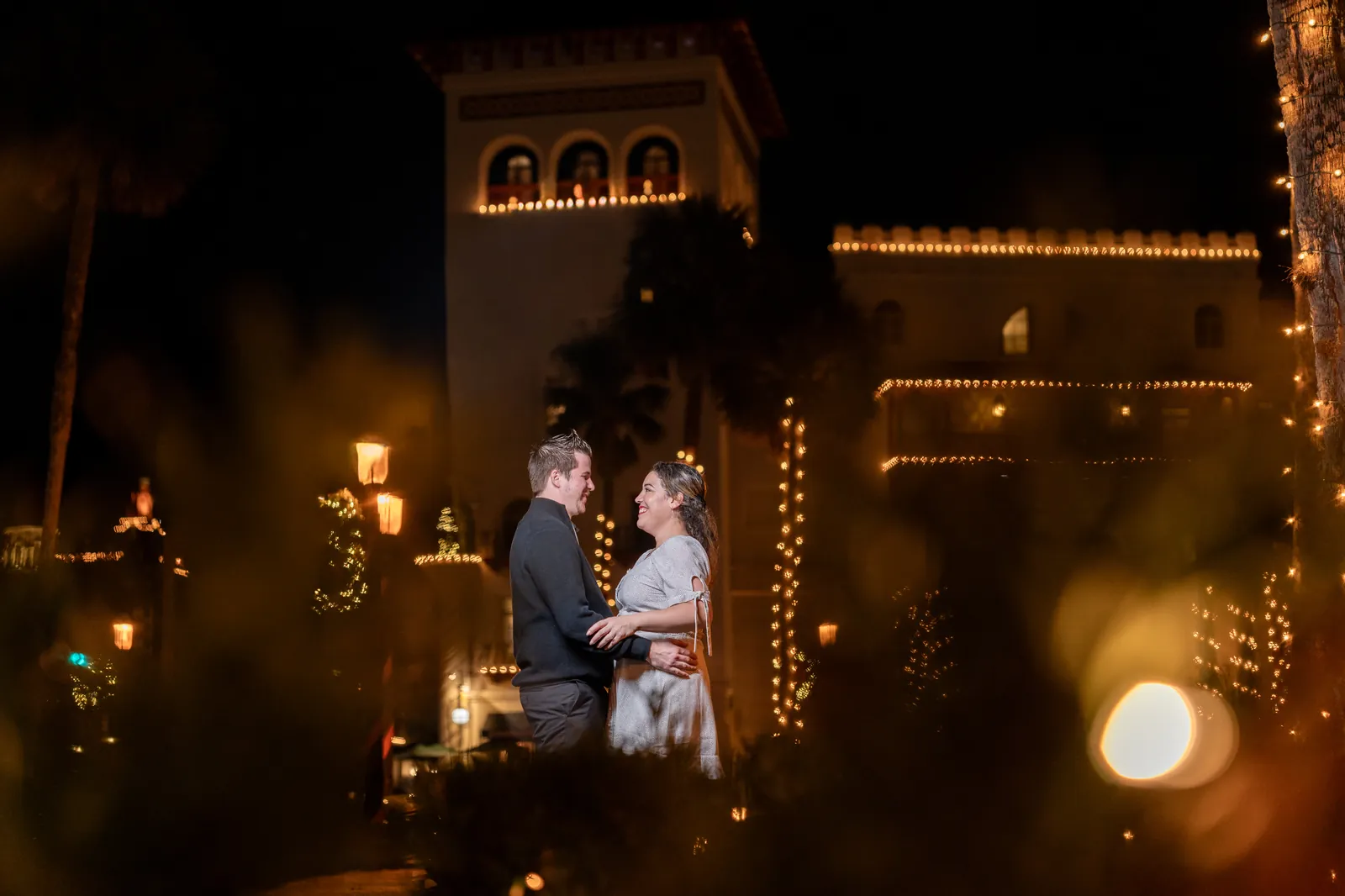 Romantic portrait with Flagler College tower lit up during Nights of Lights