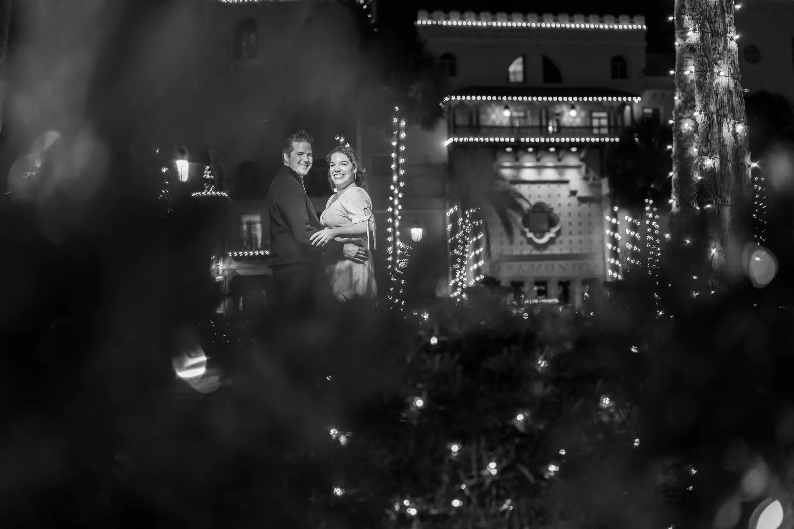 Black and white engagement photo at Flagler College with holiday lights