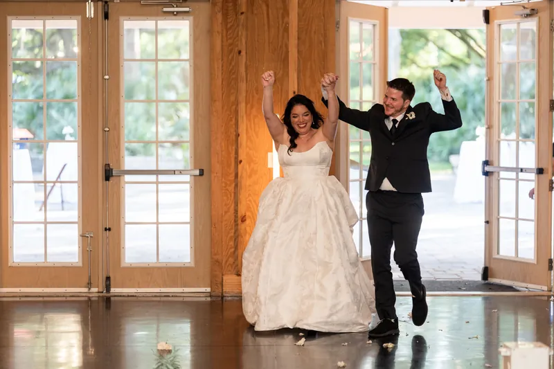 Duncan lifts Giselle in her white ball gown through open wooden doors as they celebrate their first dance.