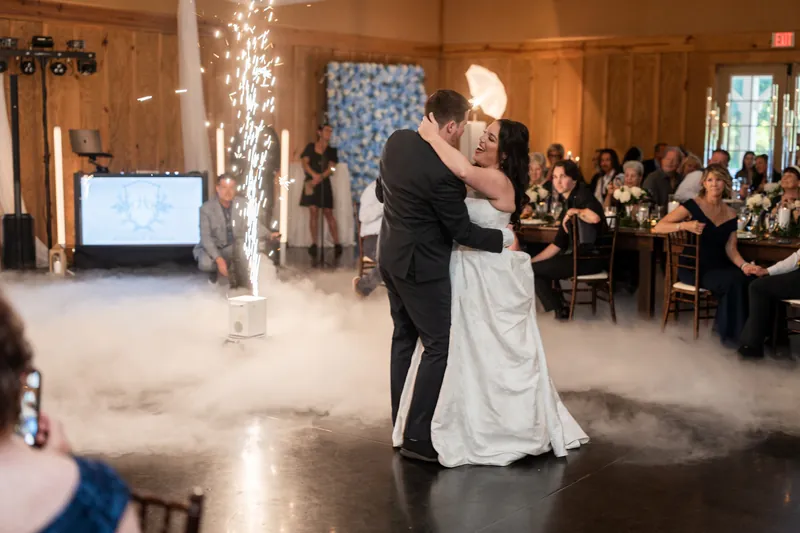 Duncan dips Giselle in her wedding dress during their first dance as guests watch from tables.