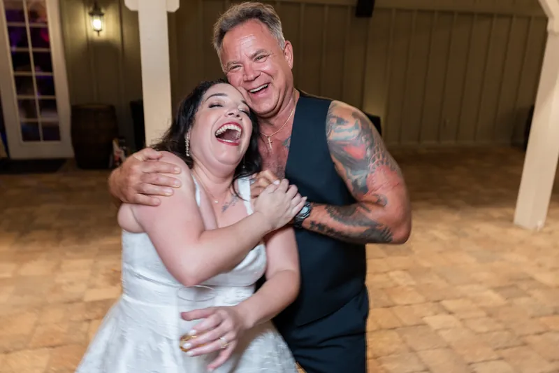 Duncan embraces Giselle while laughing on the dance floor, both beaming.