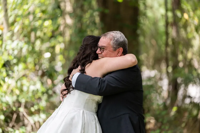 Giselle embraces her father under canopy of Spanish moss as he wipes away tears.