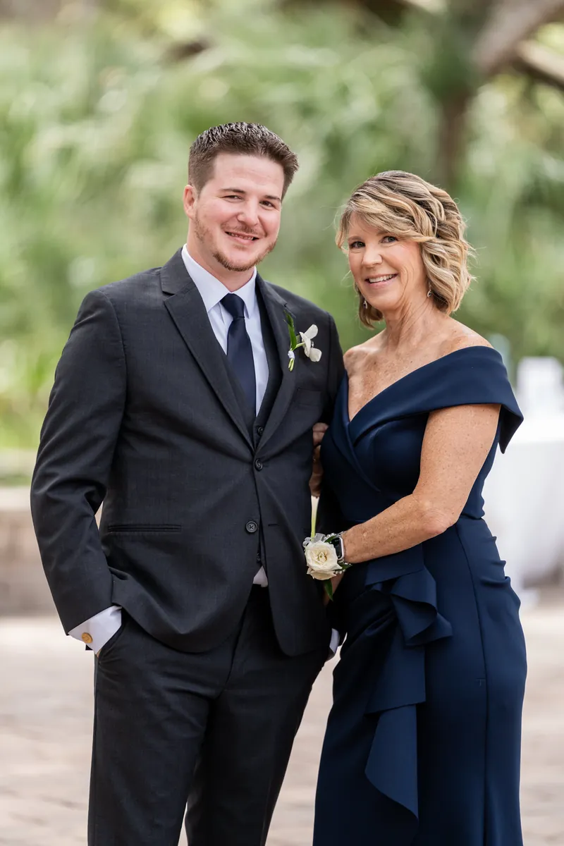 Duncan and Giselle smile together, she in a navy off-shoulder dress, he in a dark suit.