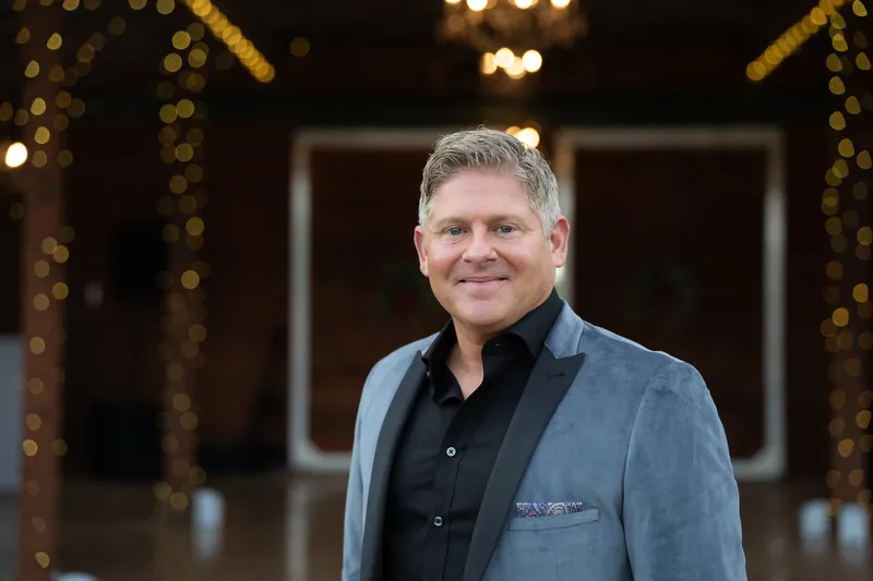 Hamilton groom portrait in barn with string lights at Kelly Farm Events