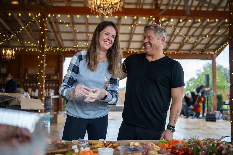 Hamilton and Michelle laughing at grazing table before wedding