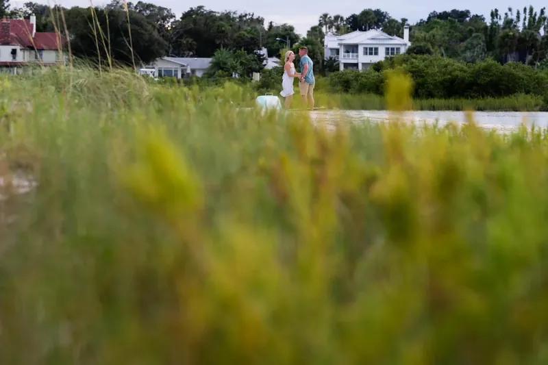 Couple facing each other on sandbar after proposal