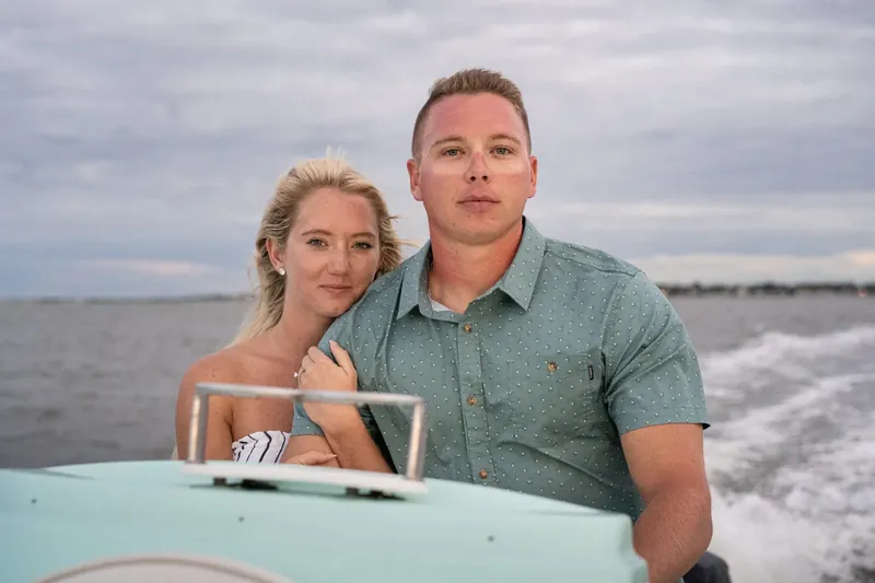 Couple portrait on moving boat with wake behind