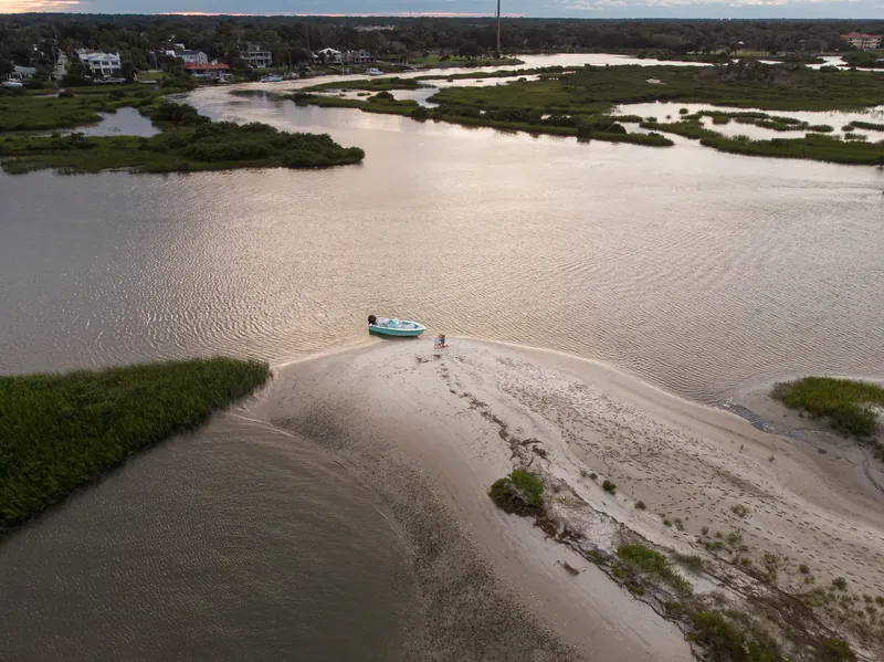 Drone view of sandbar and marsh at sunset