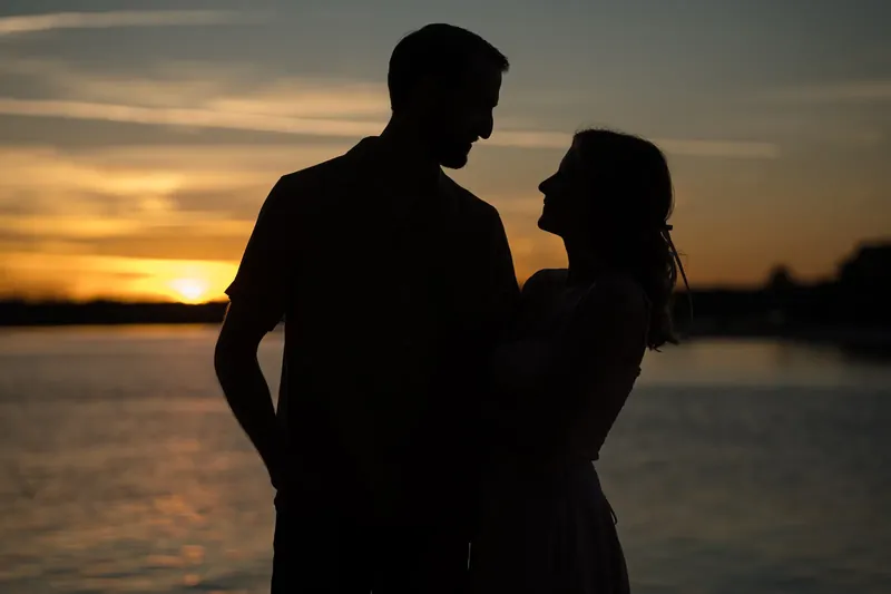 Helen and Saje silhouette against sunset over the waterfront