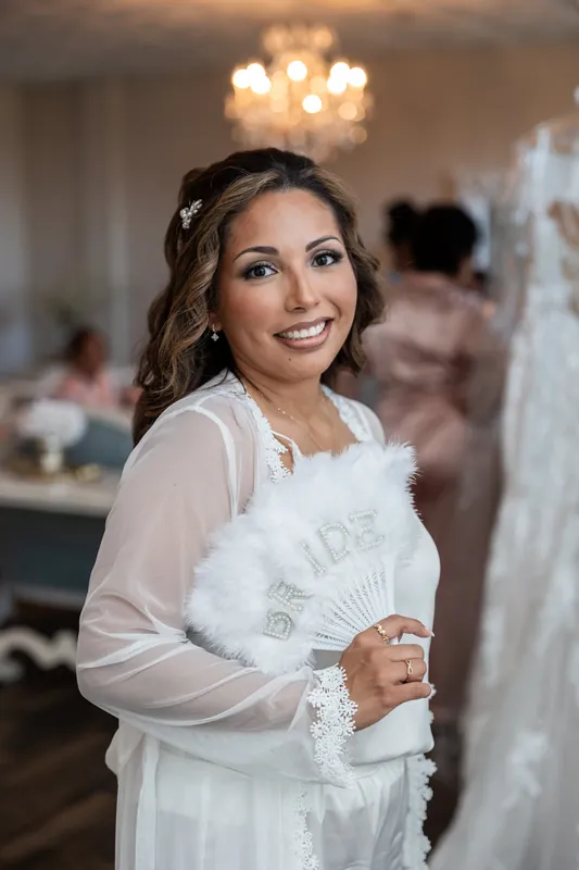 Janet smiles warmly in an elegant white lace gown with sheer sleeves at The White Room, St. Augustine.