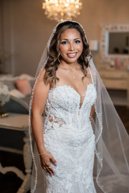 Janet wears a beaded white gown with pearled veil and smiles at The White Room in St. Augustine.