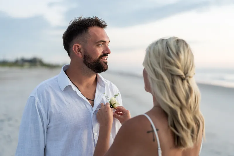 Jarah adjusts Brandon's shirt collar while he looks toward the ocean on Vilano Beach.