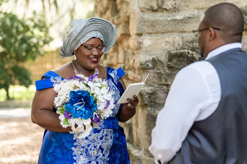 Jazzalynn and Hakeem exchange vows beside ivy-covered stone architecture during their ceremony.