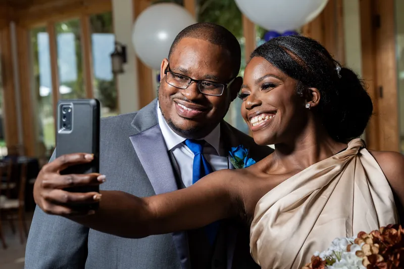 Hakeem and Jazzalynn take a selfie together, both smiling, with the wooden pavilion interior visible behind them.