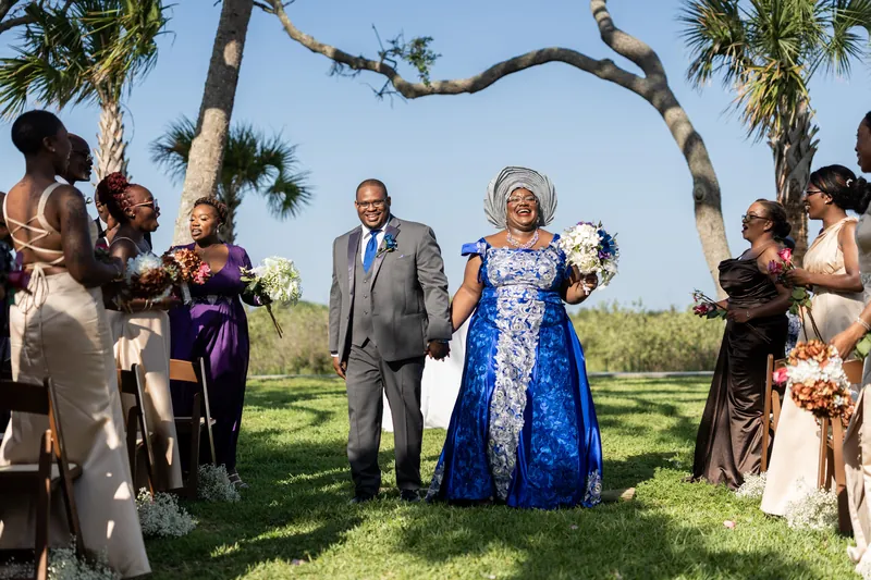 Family members stand in a semicircle around the couple under gnarled oak branches during the celebration.