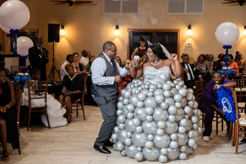 Hakeem in a gray vest and white shirt dances with Jazzalynn, who wears a flowing white ball gown surrounded by gray and white