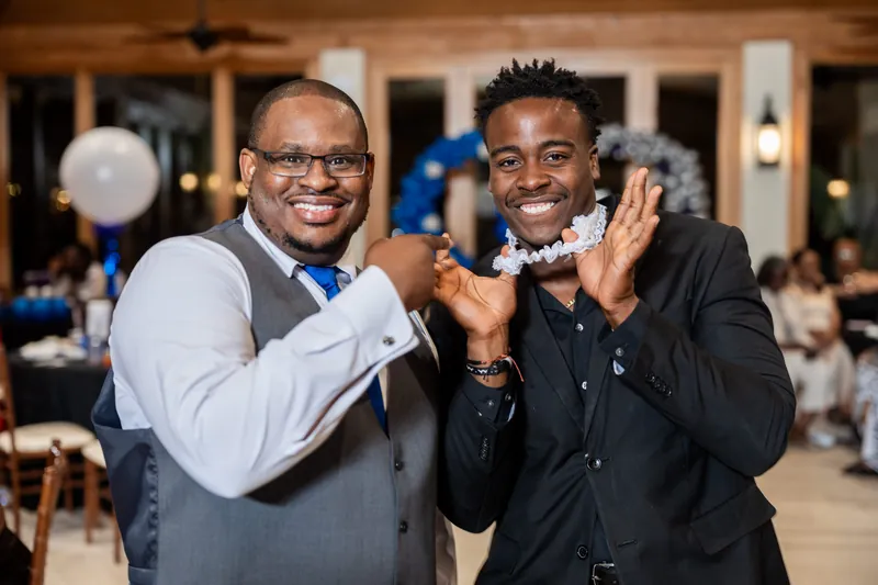 Two guests in formal wear make a playful fist bump while posing during the reception at Fountain of Youth Archaeological