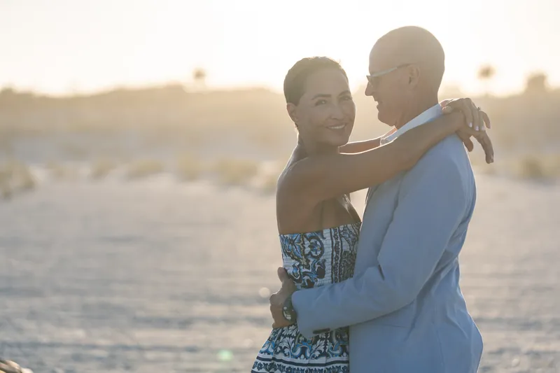 A couple holds each other close during golden hour on the sand at St. Augustine Beach.