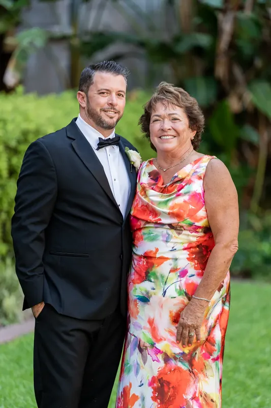 Russell and his mother pose together against the lush green backdrop of the courtyard gardens.