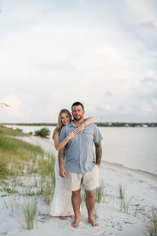 Jenna wraps her arm around Russell while they pose together on the sandy shore at Matanzas Inlet.