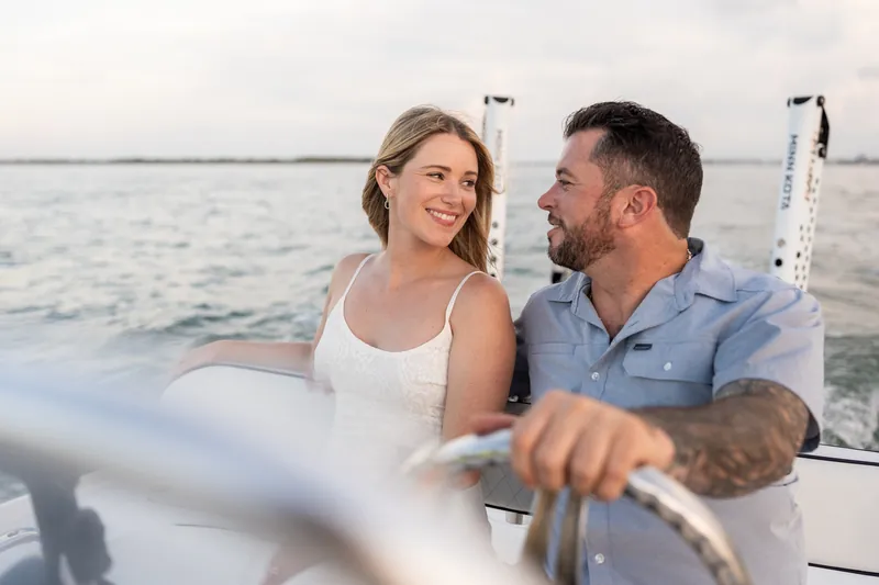 Seated at the helm, Russell and Jenna gaze at one another while steering through Matanzas Inlet's calm waters.